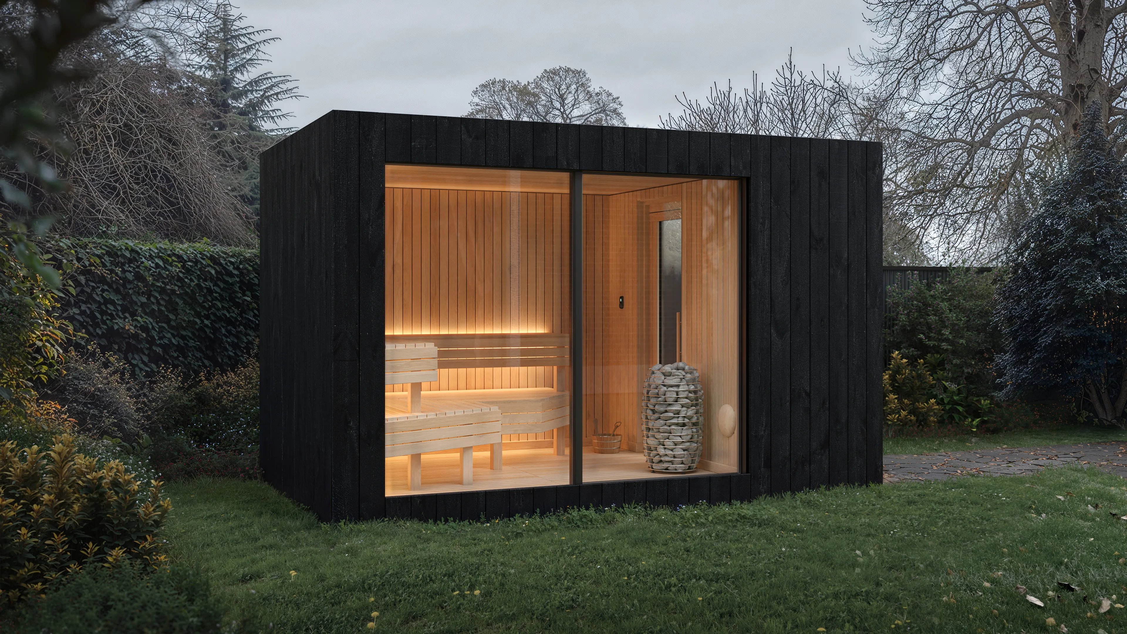 The black cabin glowing at blue hour — the warm point in a cold landscape